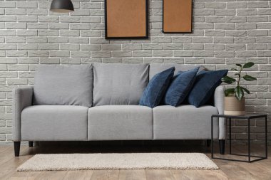 Güzel, şık bir oda, rahat bir kanepe, halı ve çiçekli.