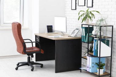 Çalışma yeri, koltuğu, modern bilgisayarı ve raf ünitesi olan şık bir ofis.