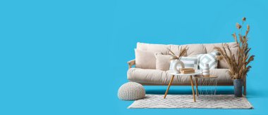 Rahat beyaz kanepe, masa ve dekorasyonlar mavi arkaplanda metin için yer var