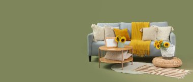 Gri kanepe, masa ve pouf yeşil arka planda metin için boşluk