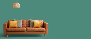 Yastıklı rahat kanepe ve yeşil arka planda metin için yeri olan lamba.