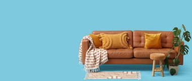 Açık mavi arkaplan üzerinde minderli, ekose, dışkılı ve çiçekli koltuk ve metin için boşluk