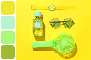 Taşınabilir elektrikli vantilatör ve sarı arka planda şık bayan aksesuarları olan kompozisyon