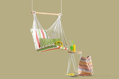 Hamak, plaj aksesuarları ve yeşil arka planda tabureye kokteyl asmak. Seyahat kavramı