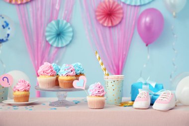 Masada mavi arka planda bebek paçası ve süslemeleri olan enfes kekler. Cinsiyet ortaya çıkan parti kavramı