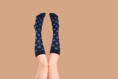 Bej arka planda çoraplı genç kadın bacakları