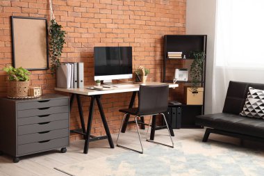 Çalışma yeri, raf ünitesi ve çekmeceleri olan modern ofis.
