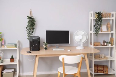 Modern bilgisayarlı rahat çalışma alanı ve çağdaş odada taşınabilir güç istasyonu