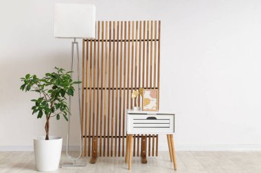 İçinde sehpa, saksı, lamba ve katlanan ekran olan odanın içi.