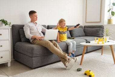 Çalışan baba, küçük oğlunun evde televizyon izlemesinden rahatsız oldu.