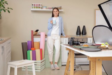 Mutfakta bir fincan kahve ile genç bayan yemek fotoğrafçısı.