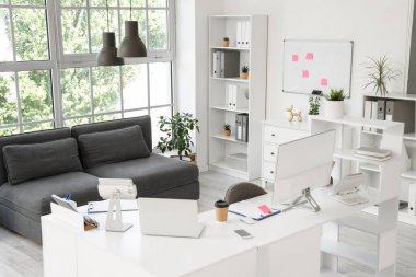 Çalışma yeri, kanepesi ve raf üniteleri olan modern ofis.