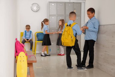 Okul salonunda konuşan küçük çocuklar.