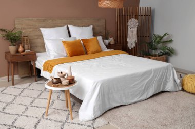 Yatak odasının içinde masalar ve katlanmış ekran var.