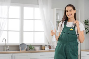 Mutfakta hortumları olan kadın tesisatçı.