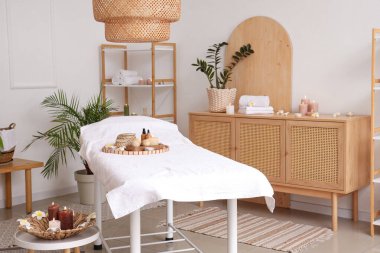 Masaj koltuğu, yanan mumları ve çekmeceleri olan bir kaplıca salonu.