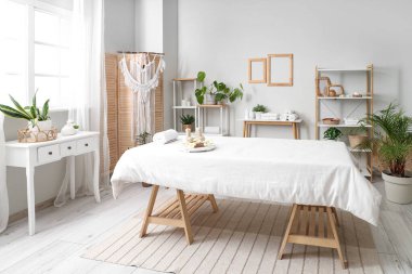 Masaj koltuğu, raf ünitesi ve masaları olan bir kaplıca salonu.