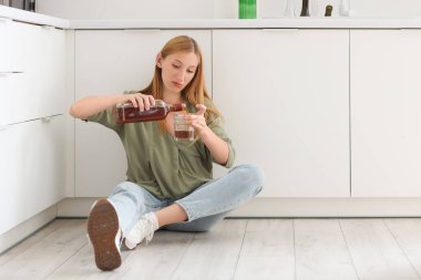 Evde alkol alan genç bir kadın. Alkolizm kavramı