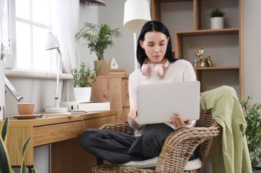 Ev ofis masasında laptop ile çalışan genç kadın