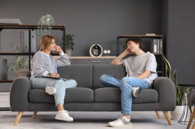 Ofisteki kanepede oturan psikologu olan genç bir çocuk.