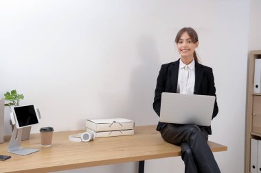 Ofiste modern dizüstü bilgisayarla çalışan güzel genç bir iş kadını.