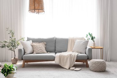 Ekoseli, çiçekli rahat bir kanepe ve oturma odasının içinde puf.