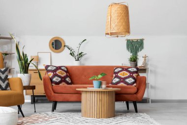 Ayna, kırmızı kanepe ve masalı aydınlık oturma odasının içi.