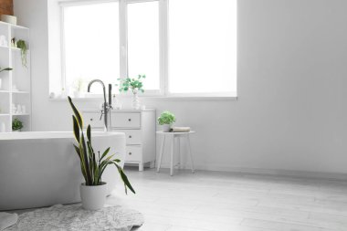 Küveti, lavabosu ve raf ünitesi olan şık bir banyo.