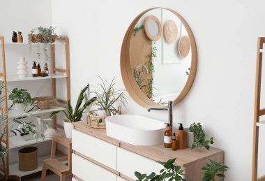 Çekmeceli, aynalı, lavabolu ve raflı güzel bir banyo.