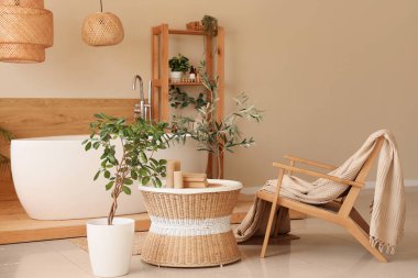 İçinde sehpası, küveti, saksısı ve koltuğu olan rahat bir tuvalet.