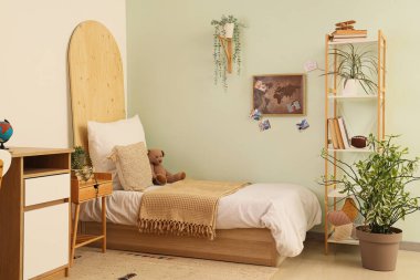 Rahat yatak ve dünya haritası renkli duvarlı modern çocuk odasının şık iç tasarımı