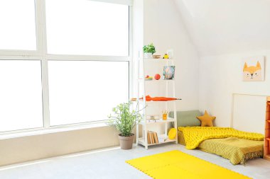 İçinde yatak, raf ünitesi ve oyuncaklar olan hafif çocuk odası.