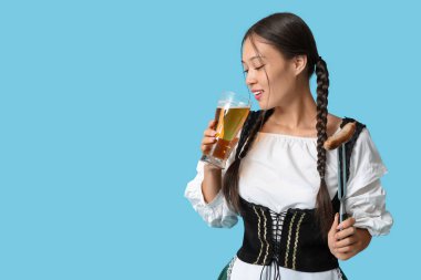 Genç Ekim Festivali garsonu. Mavi arka planda bir bardak bira ve sosisle.