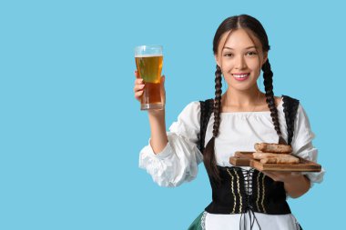 Genç Ekim Festivali garsonu. Mavi arka planda bir bardak bira ve sosisle.