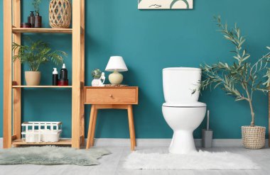 Tuvaleti, masası ve raf ünitesi olan bir tuvalet.