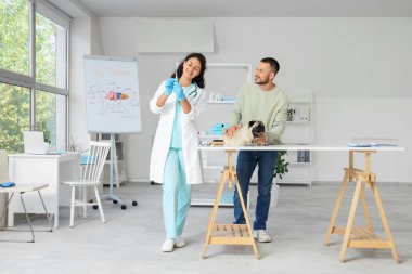 Kadın Afro-Amerikalı veteriner klinikte köpek aşısı yaptırıyor.