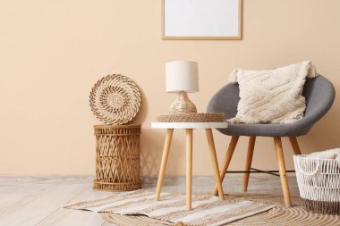 Odadaki bej duvarın yanındaki sehpada yastıklı ve lambalı koltuk.