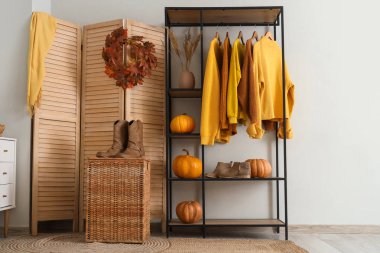 Giysi askısı, balkabağı ve katlama perdesi olan soyunma odasının içinde.