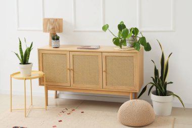 Odanın içinde ahşap tuvalet, masa ve bitkiler var.