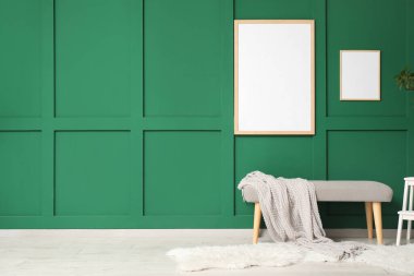 Ekose ve çerçeve ile bankta yeşil duvarda oda