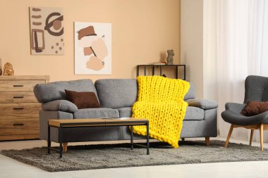 Şık kanepesi, koltuğu ve sarı örülü ekoseli modern oturma odası.