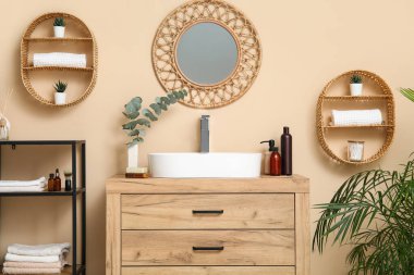 Beyaz seramik lavabo ve banyoda ahşap çekmeceler.