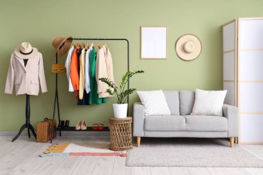 İçinde manken, elbise askılığı ve kanepe olan bir soyunma odası.