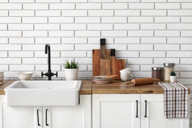 Seramik lavabosu ve mutfakta tabakları olan ahşap tezgah. Yakın çekim.