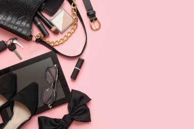 Pembe arka planda şık kadın aksesuarları, kozmetik ürünleri ve tablet bilgisayarlı kompozisyon