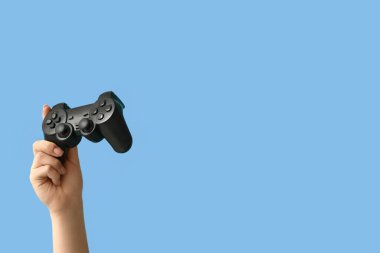 Renk arkaplanına karşı modern oyun yastığına sahip kadın el