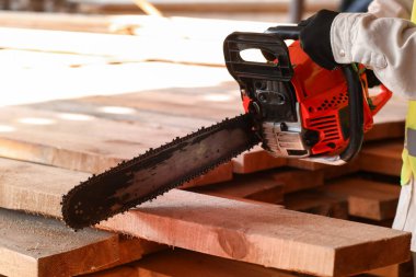 Testereli erkek marangoz kereste fabrikasında çalışıyor, yakın plan.