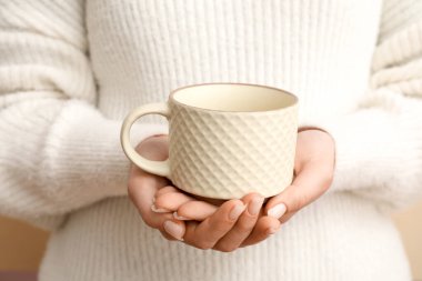 Beyaz seramik bardak tutan kadın, yakın plan.