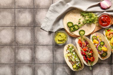 Taze lezzetli tacolar ve gri fayanslı malzemeler.