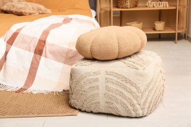 Yumuşak puf ve yataklı şık bir yatak odası.